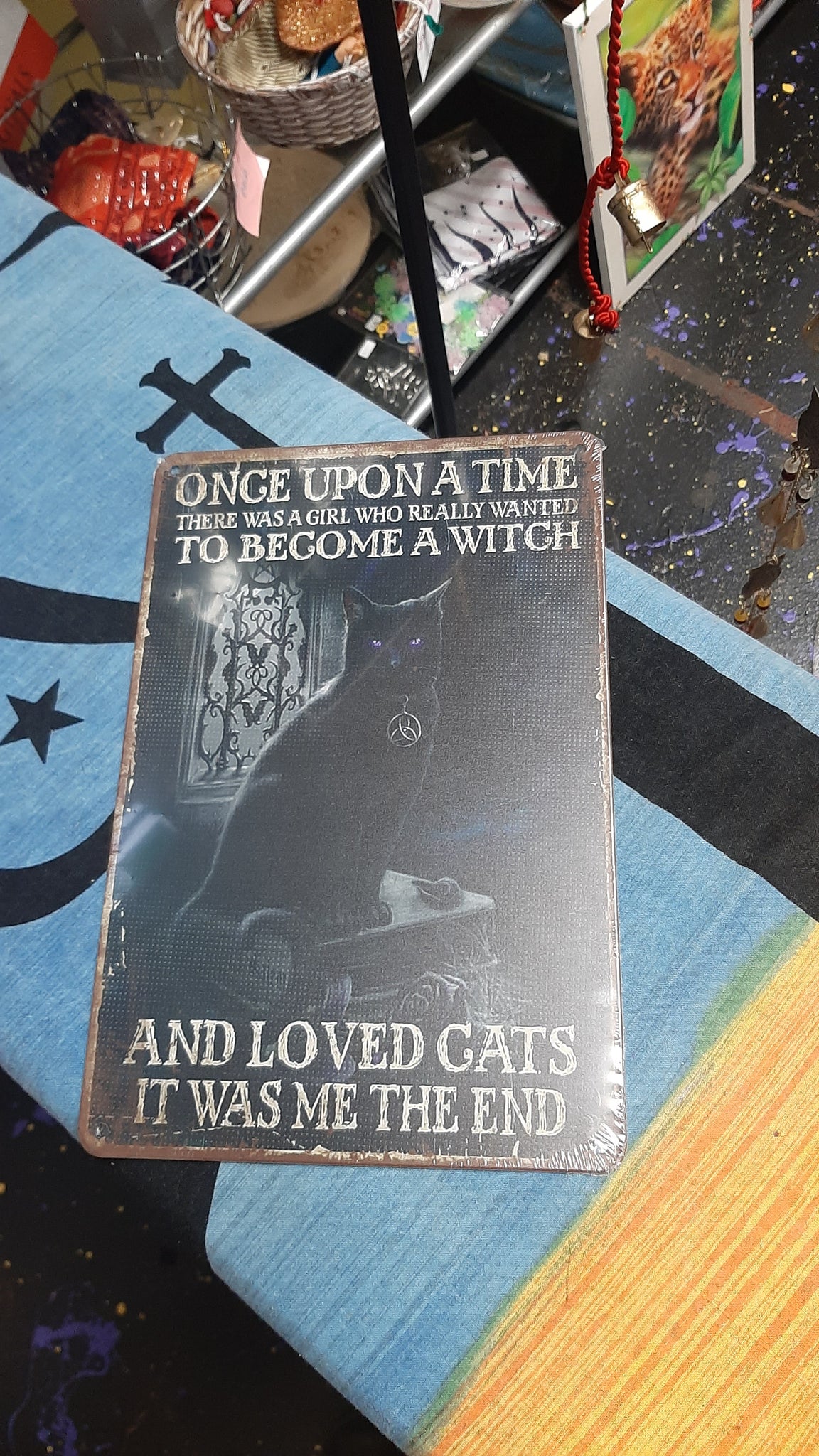 Decorative cat tin sign with text on a colorful surface