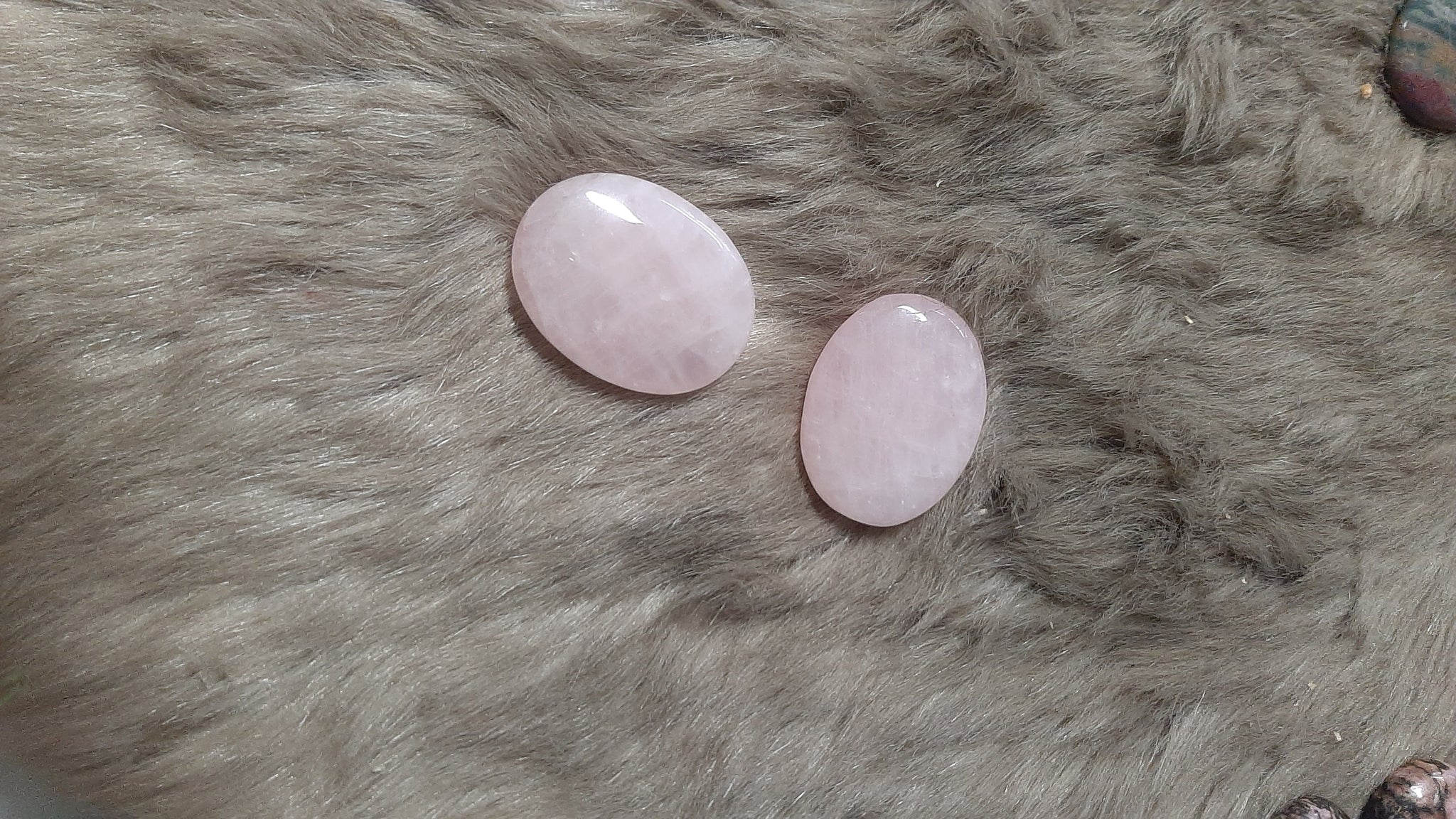 Two pink stones on a gray fur surface